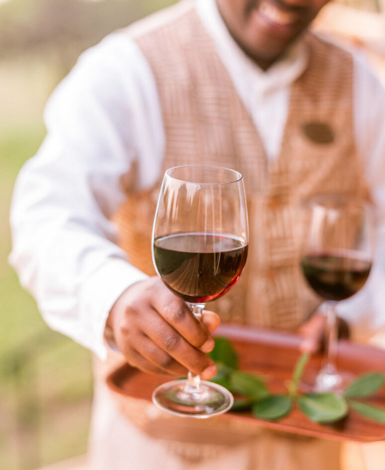 waiter holding two glasses or red wine