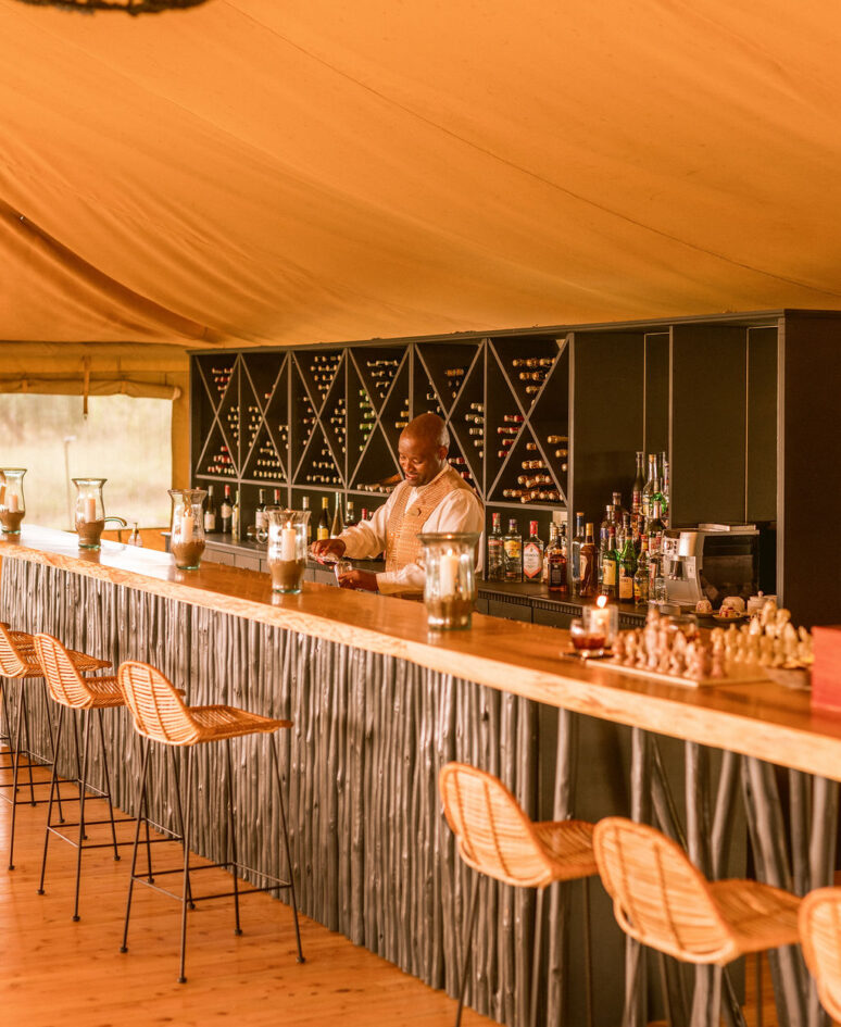 bar man making a cocktail behind a bar