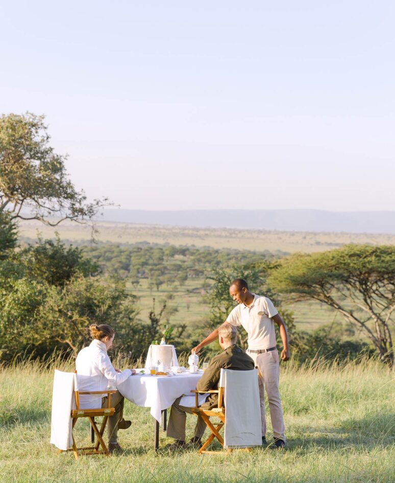 A server presenting breakfast to a couple