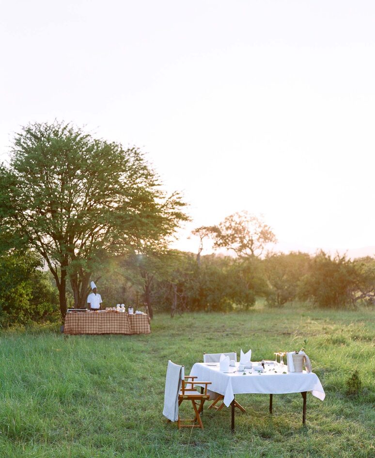 A chef prepares breakfast in the grass