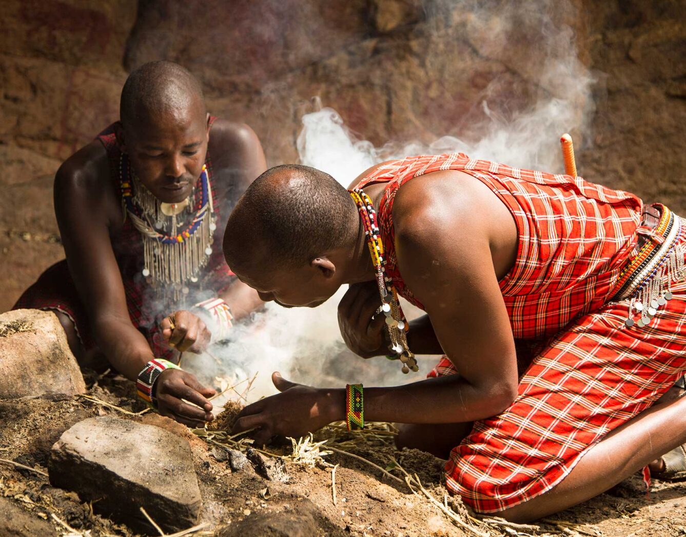 Two men starting a fire