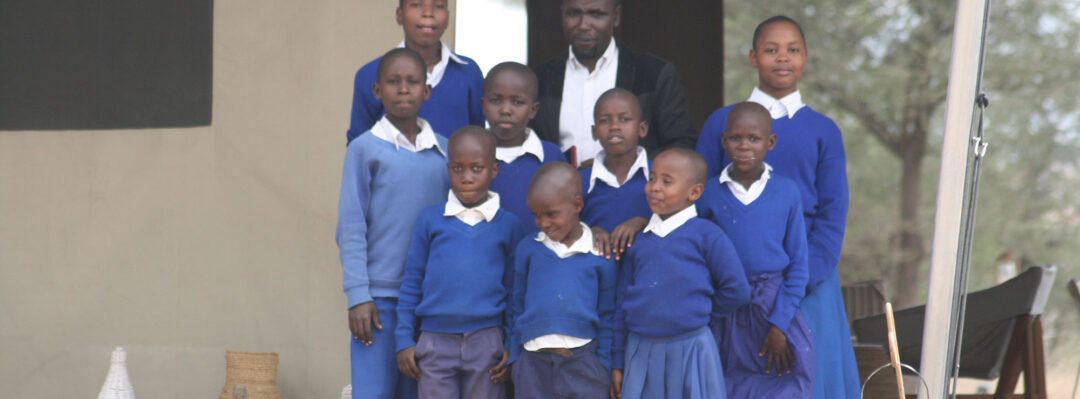 A teacher stands with a group of their students