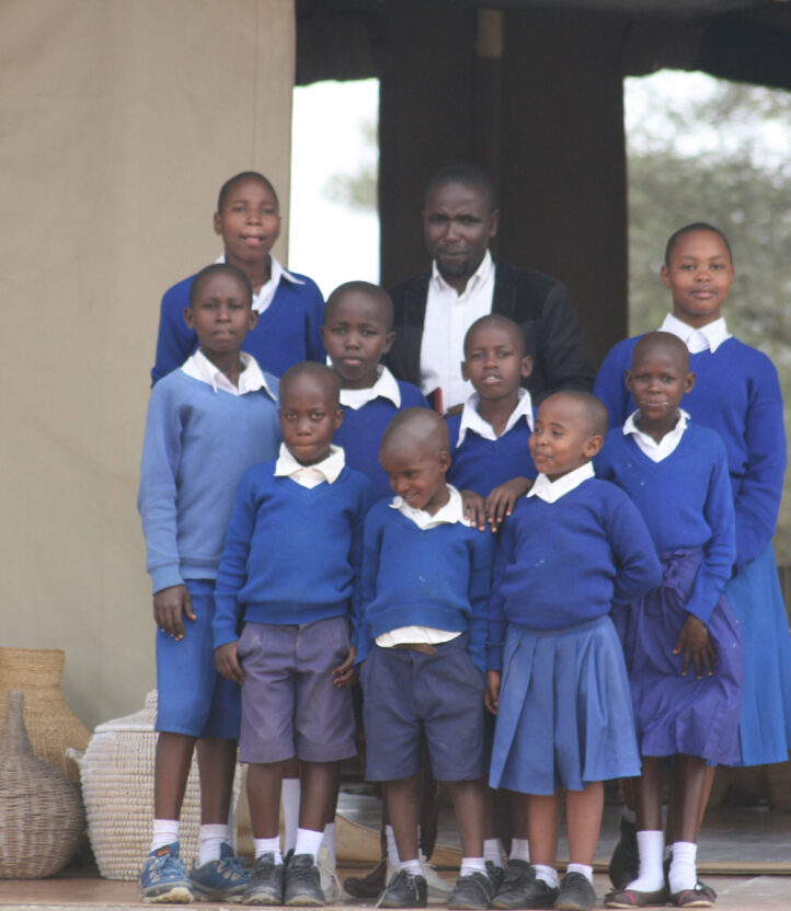 A teacher stands with a group of their students