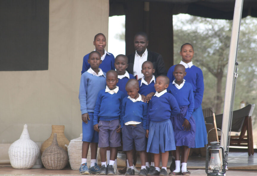 A teacher stands with a group of their students